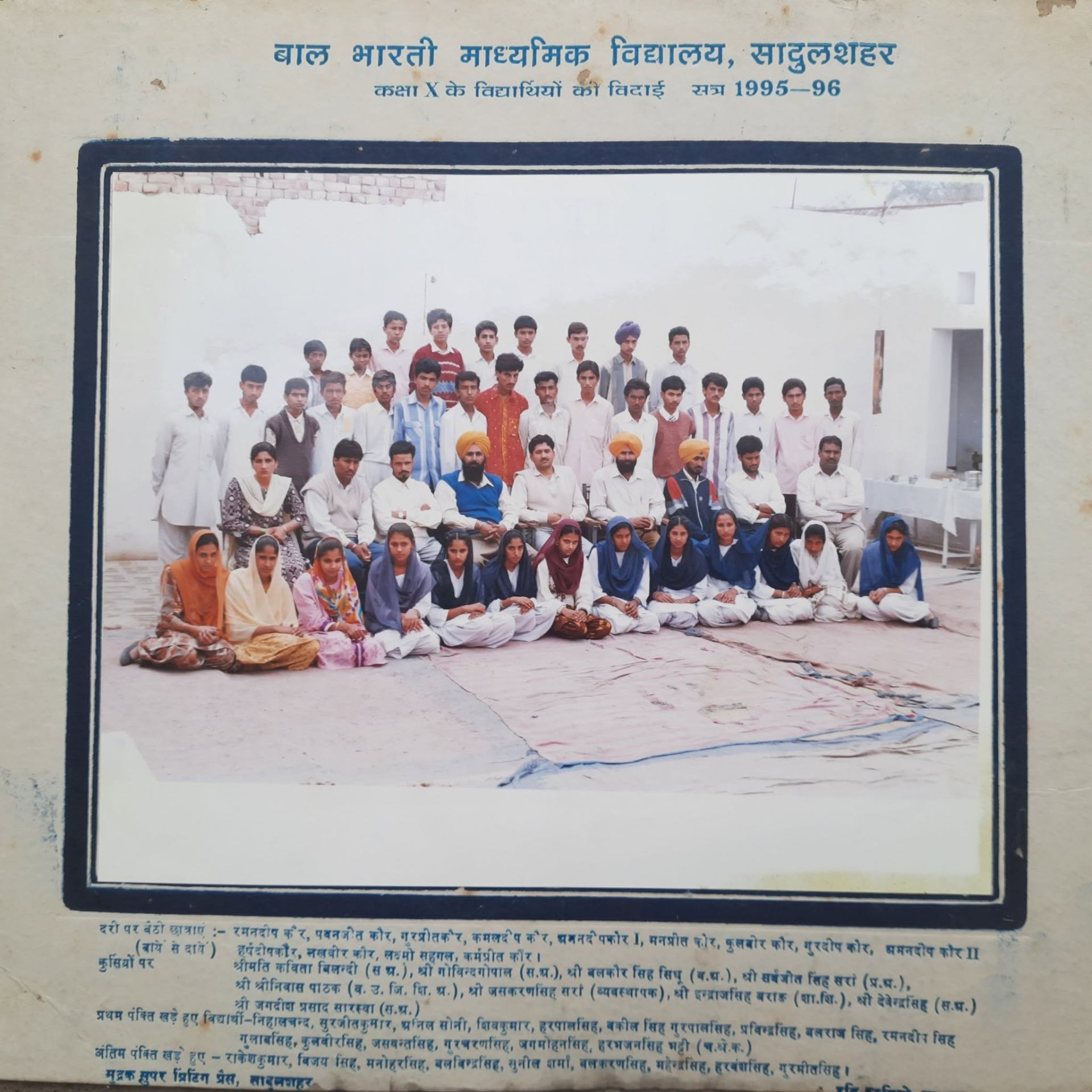 Girls' batch group portrait under the Gurmukhi arch with founders